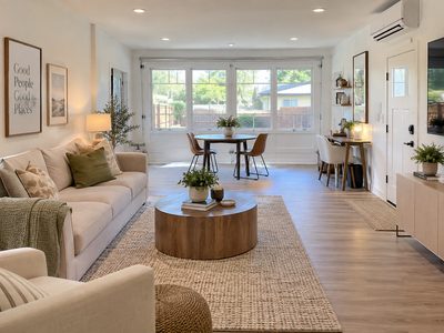 Garage converted into a bright, finished living space with hardwood floors and a mini split